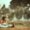 A little girl sits on the grass, deeply focused on a book,